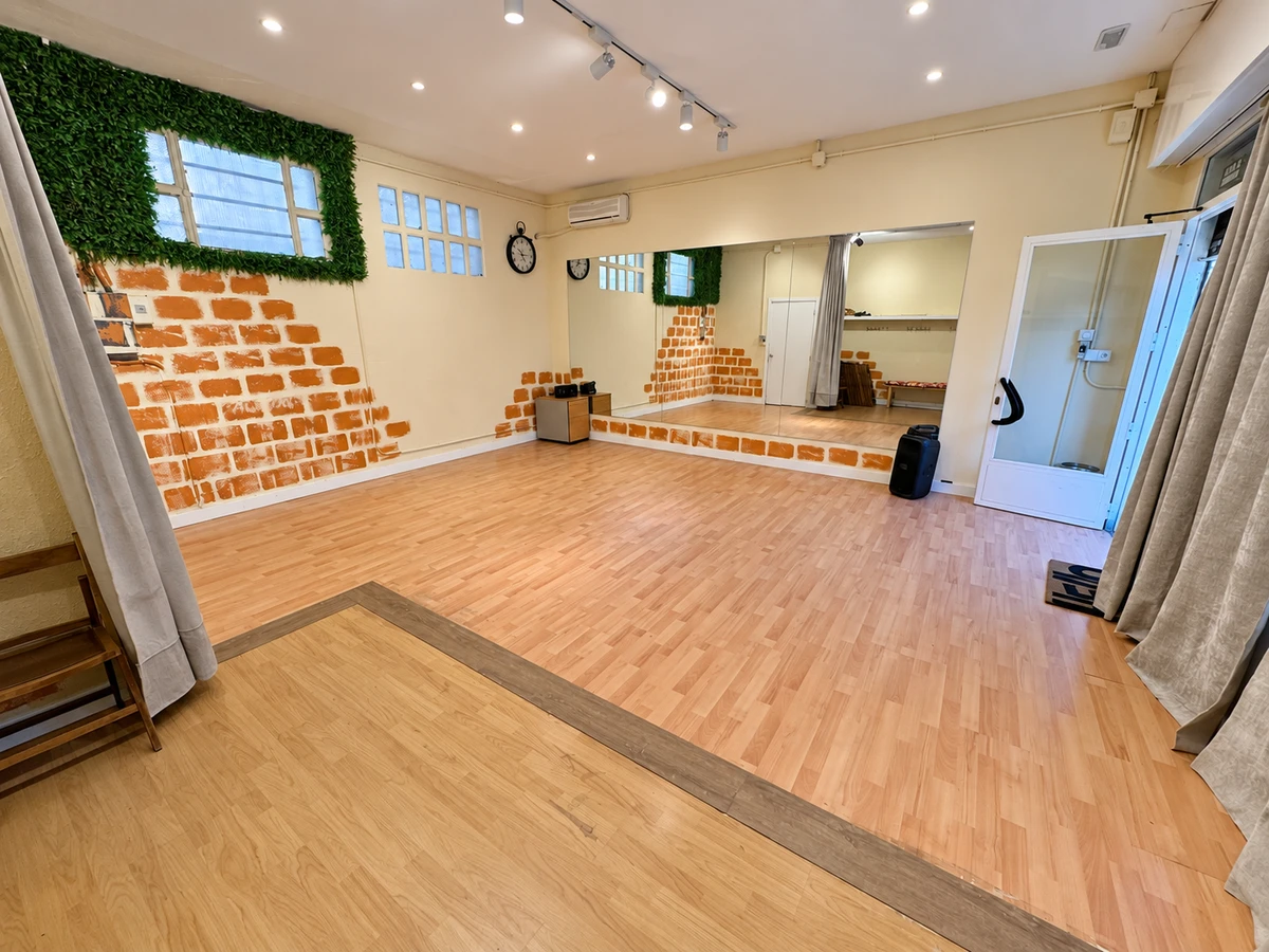 Sala Café: espejo, ventanas altas y motivo de ladrillo pintado en la pared